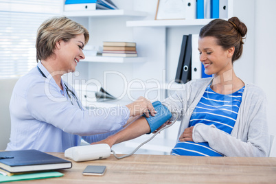 Female doctor checking blood pressure of a patient