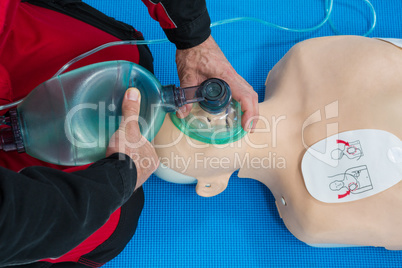 Paramedic practicing resuscitation on dummy