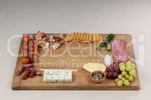 Roquefort cheese, biscuits and ham with various ingredients on chopping board