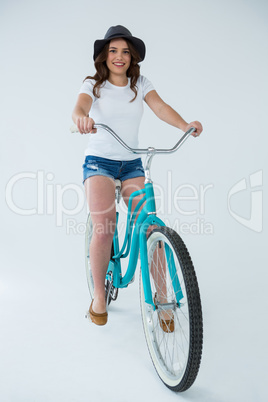 Happy woman in white t-shirt and hot pants on bicycle