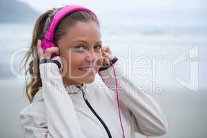 Beautiful woman listening music on headphones at beach