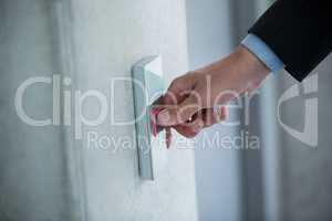 Hand of a businessman pressing the button in an elevator