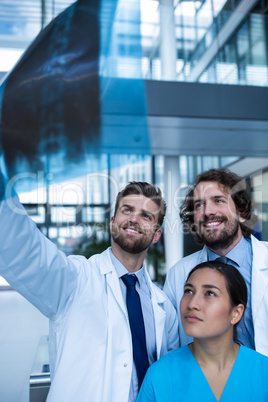 Doctors and nurse examining X-ray report