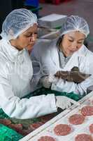 Female butcher processing hamburger patty