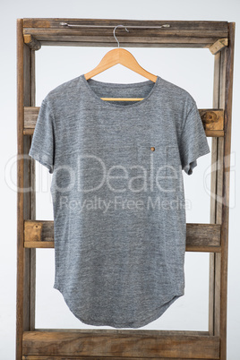 Grey t-shirt hanging on wooden frame