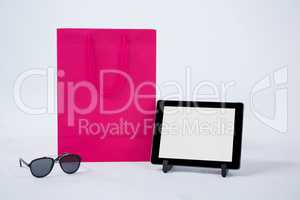 Shopping bag with sunglasses and digital tablet