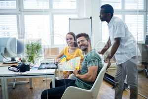 Graphic designer discussing over color swatch with a colleague