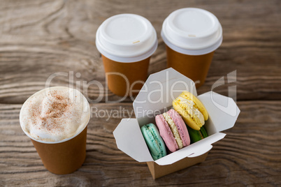 Macaroons with coffee on wooden table
