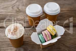 Macaroons with coffee on wooden table