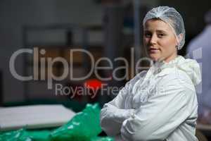 Female butcher standing with arms crossed