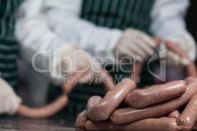 Butchers processing sausages