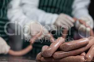 Butchers processing sausages