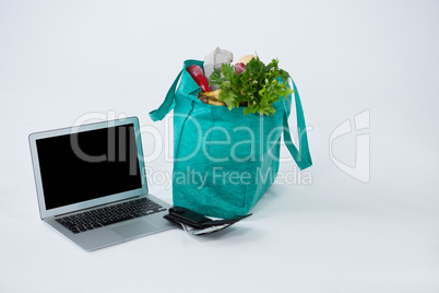 Grocery bag with wallet and laptop