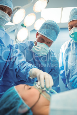 Team of surgeons adjusting oxygen mask on patient mouth in operation theater