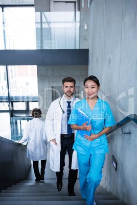 Doctor and nurse walking on staircase
