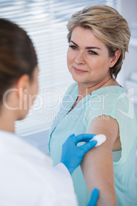 Doctor rubbing patient arm from cotton before injection