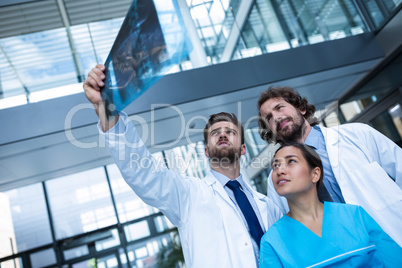 Doctors and nurse examining X-ray report