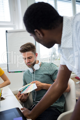 Graphic designer showing color swatch to colleague