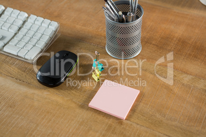 Keyboard with mouse and stationery on wooden table