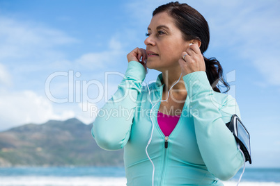 Thoughtful woman listening to music on headphones