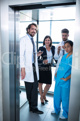 Doctors and businesswoman standing in elevator