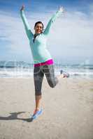 Excited woman jumping on beach