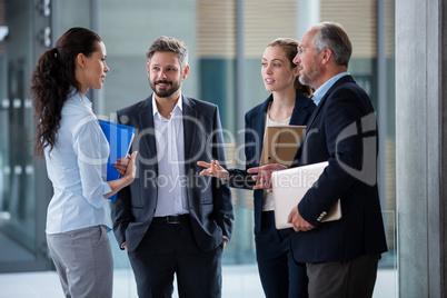 Businesspeople having a discussion in office corridor