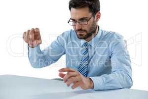 Businessman pretending to touch an invisible object at desk