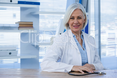 Portrait of a smiling female doctor sitting at desk