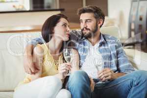 Happy couple relaxing on sofa and holding glasses of champagne