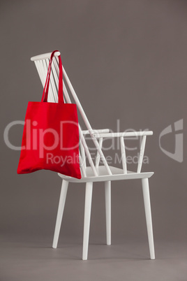 Red bag hanging on a white chair