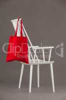 Red bag hanging on a white chair