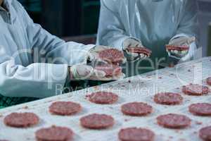 Butchers processing hamburger patty