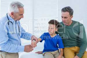 Doctor tying hand band on hand of a patient