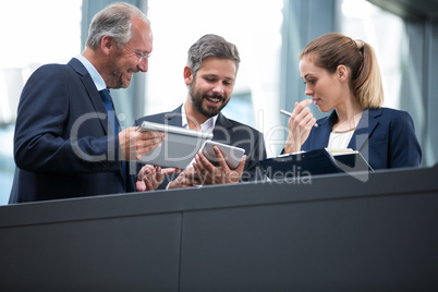 Businesspeople discussing over digital tablet