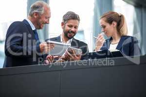 Businesspeople discussing over digital tablet