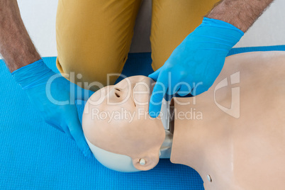 Mid section of paramedic practising resuscitation on dummy