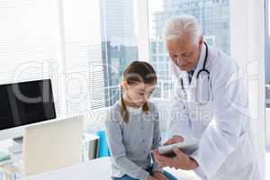 Doctor and patient discussing over digital tablet