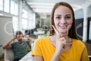 Portrait of smiling graphic designer standing with pen