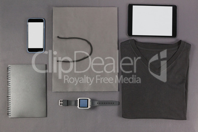 Smartphone, digital tablet, diary, folded t-shirt, shopping bag and watch