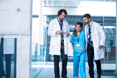 Doctor holding digital tablet having a discussion with colleagues