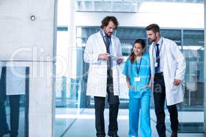 Doctor holding digital tablet having a discussion with colleagues