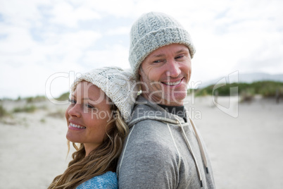 Mature couple standing back to back