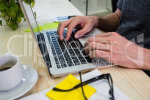 Graphic designer using laptop at his desk