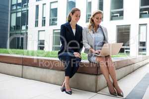 Businesswomen sitting and using laptop