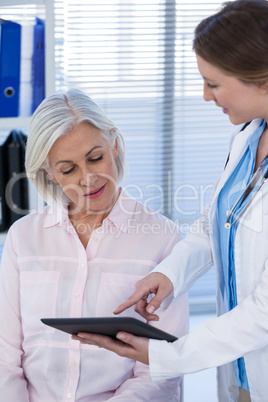 Doctor discussing with patient over digital tablet