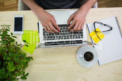 Graphic designer using laptop at his desk