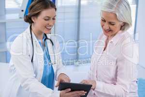 Doctor discussing with patient over digital tablet