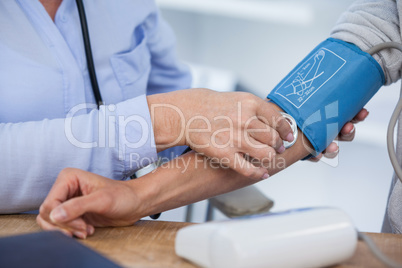 Female doctor checking blood pressure of a patient