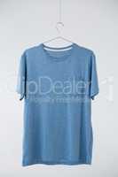 Blue t-shirt with pocket hanging on hanger